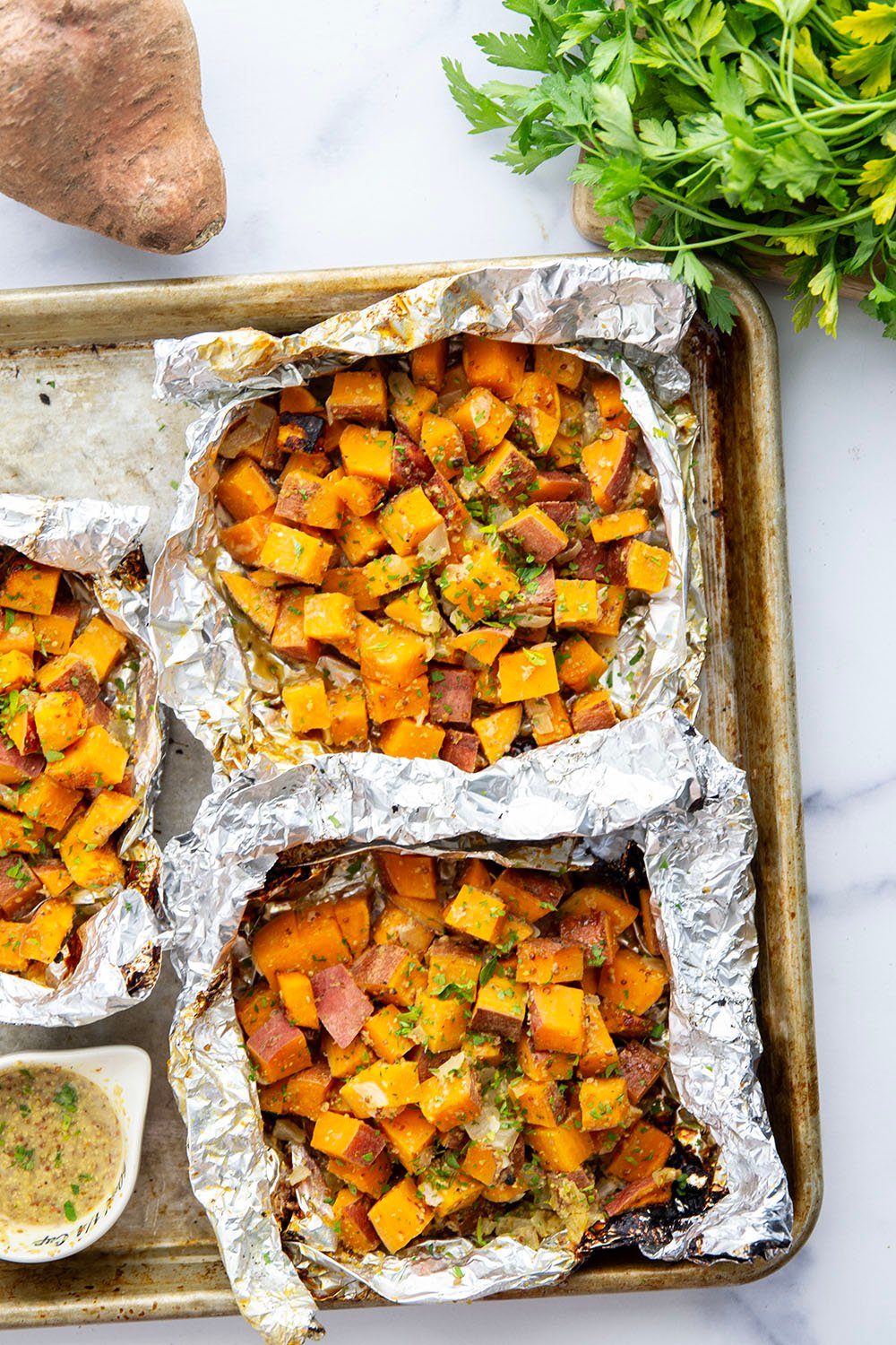 Tossed in a homemade honey mustard and grilled to tender, smoky perfection in foil packets, these grilled sweet potatoes in foil are an easy side dish to throw on the grill for any occasion.