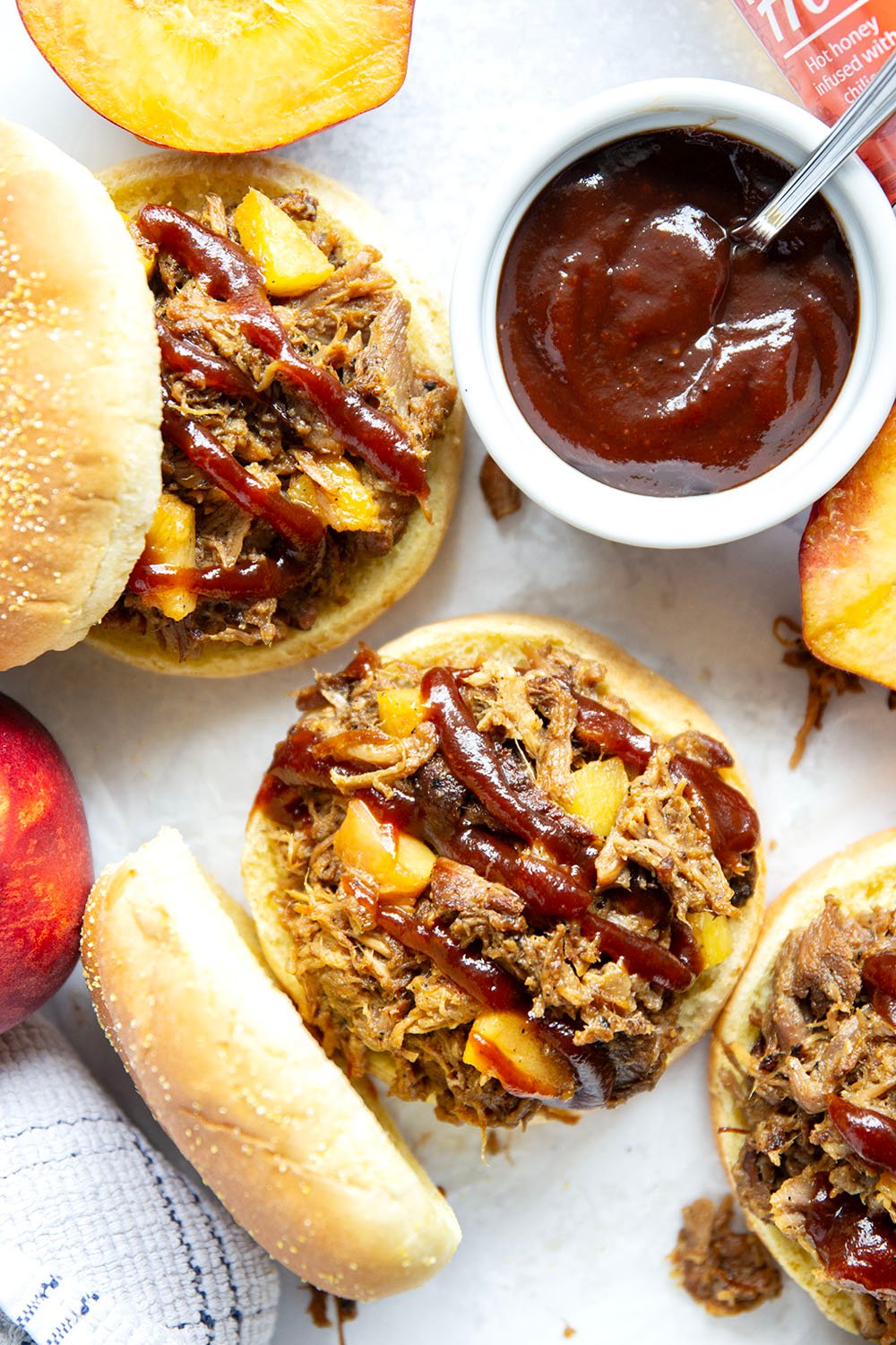 Slowly braised in sweet peaches and spicy hot honey, this peach hot honey pulled pork is fall-apart tender and makes one incredible sandwich!