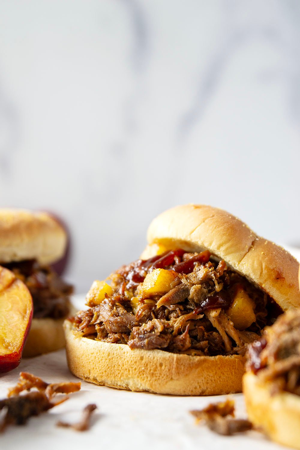 Slowly braised in sweet peaches and spicy hot honey, this peach hot honey pulled pork is fall-apart tender and makes one incredible sandwich!