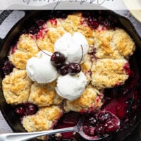 This cherry cobbler features a juicy fresh cherry filling baked with flaky browned butter biscuits on top. An incredible summer dessert warm from the oven with vanilla ice cream on top!
