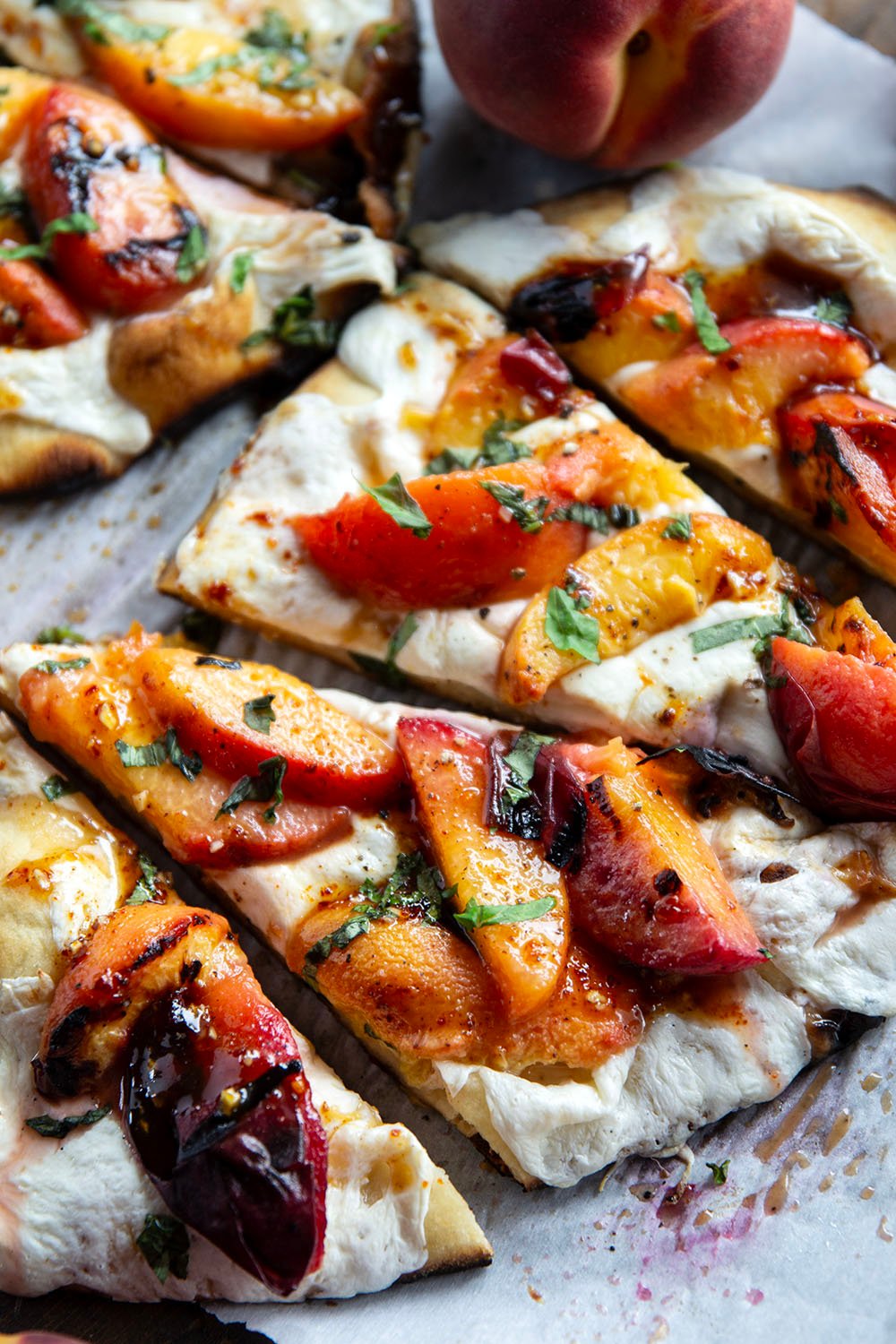 Smoky grilled peaches and drizzles of sweet and spicy homemade hot honey sauce are the perfect duo in this grilled peach flatbread.