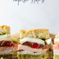 These caprese sliders feature herby basil pesto, sliced turkey, creamy burrata, and lots of fresh tomato slices layered between soft slider buns.