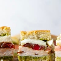 These caprese sliders feature herby basil pesto, sliced turkey, creamy burrata, and lots of fresh tomato slices layered between soft slider buns.