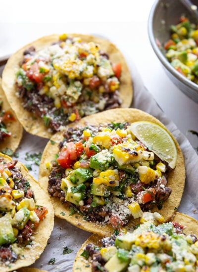 Creamy smashed black beans and a smoky grilled corn avocado salsa are piled onto these massively flavorful black bean tostadas for an easy vegetarian or vegan meal.