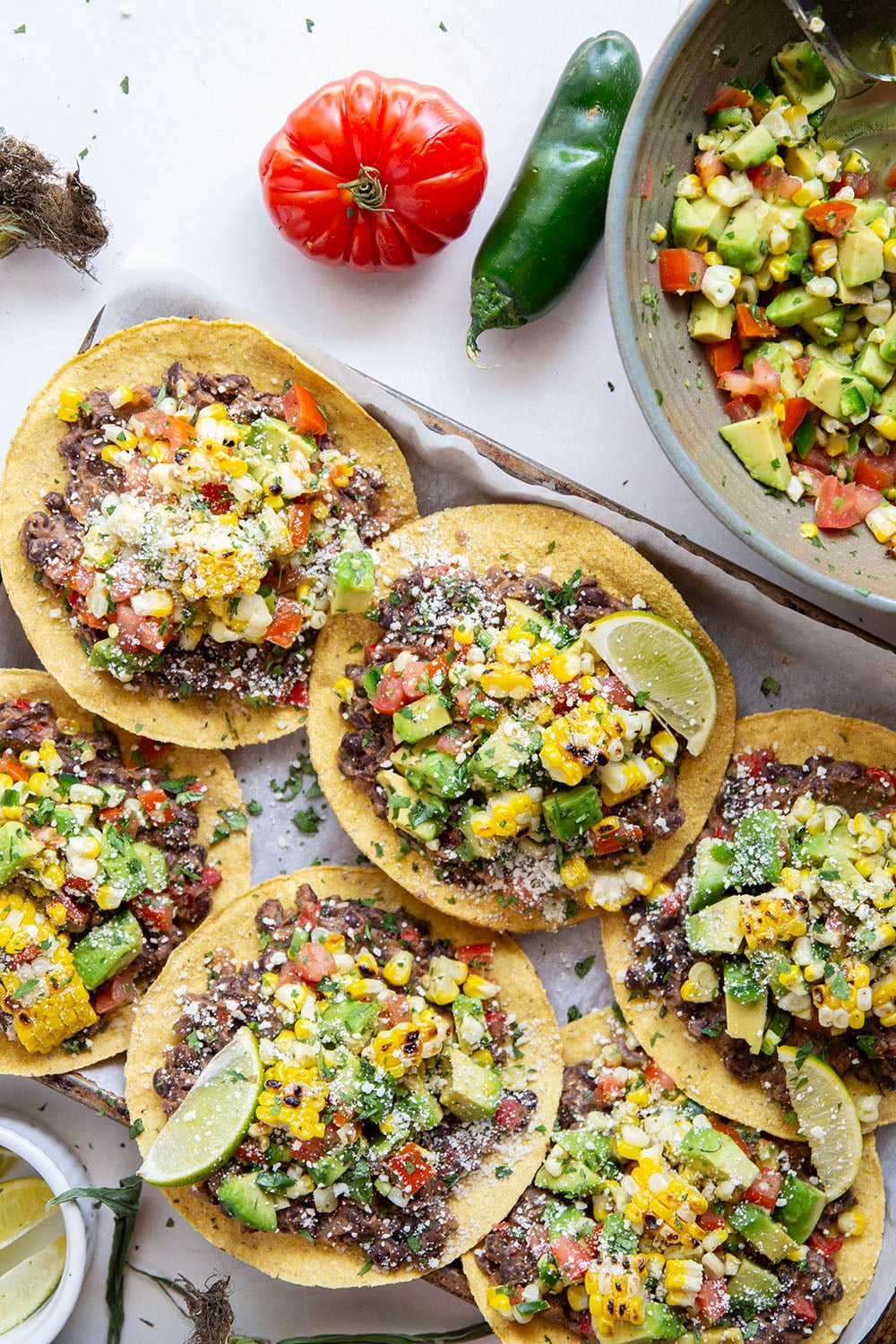 Creamy smashed black beans and a smoky grilled corn avocado salsa are piled onto these massively flavorful black bean tostadas for an easy vegetarian or vegan meal.