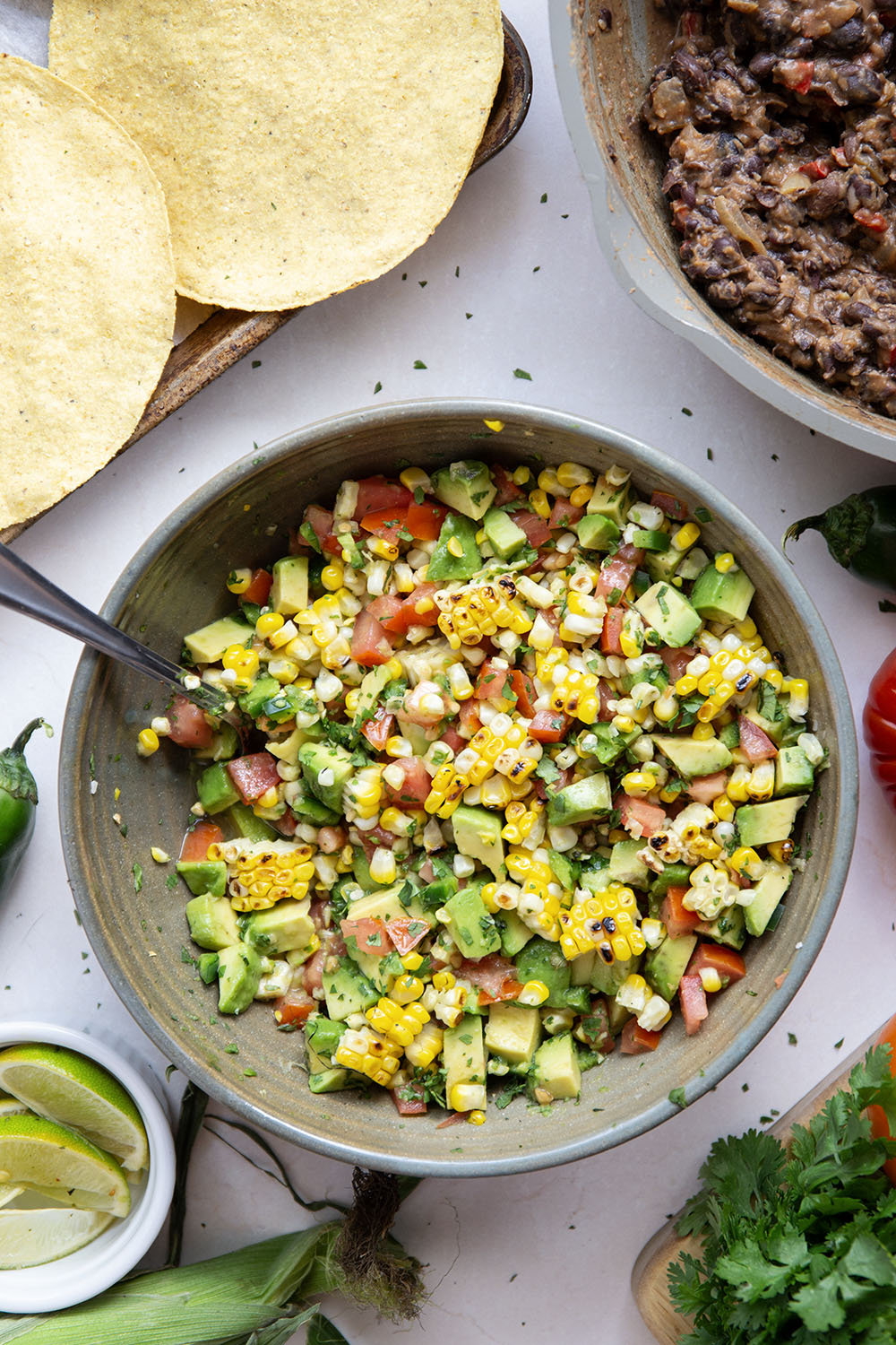 Creamy smashed black beans and a smoky grilled corn avocado salsa are piled onto these massively flavorful black bean tostadas for an easy vegetarian or vegan meal.