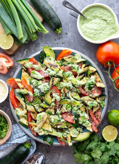 Tender zucchini is grilled until smoky and tossed with juicy summer tomatoes and a creamy avocado scallion dressing in this flavor-packed zucchini tomato salad.