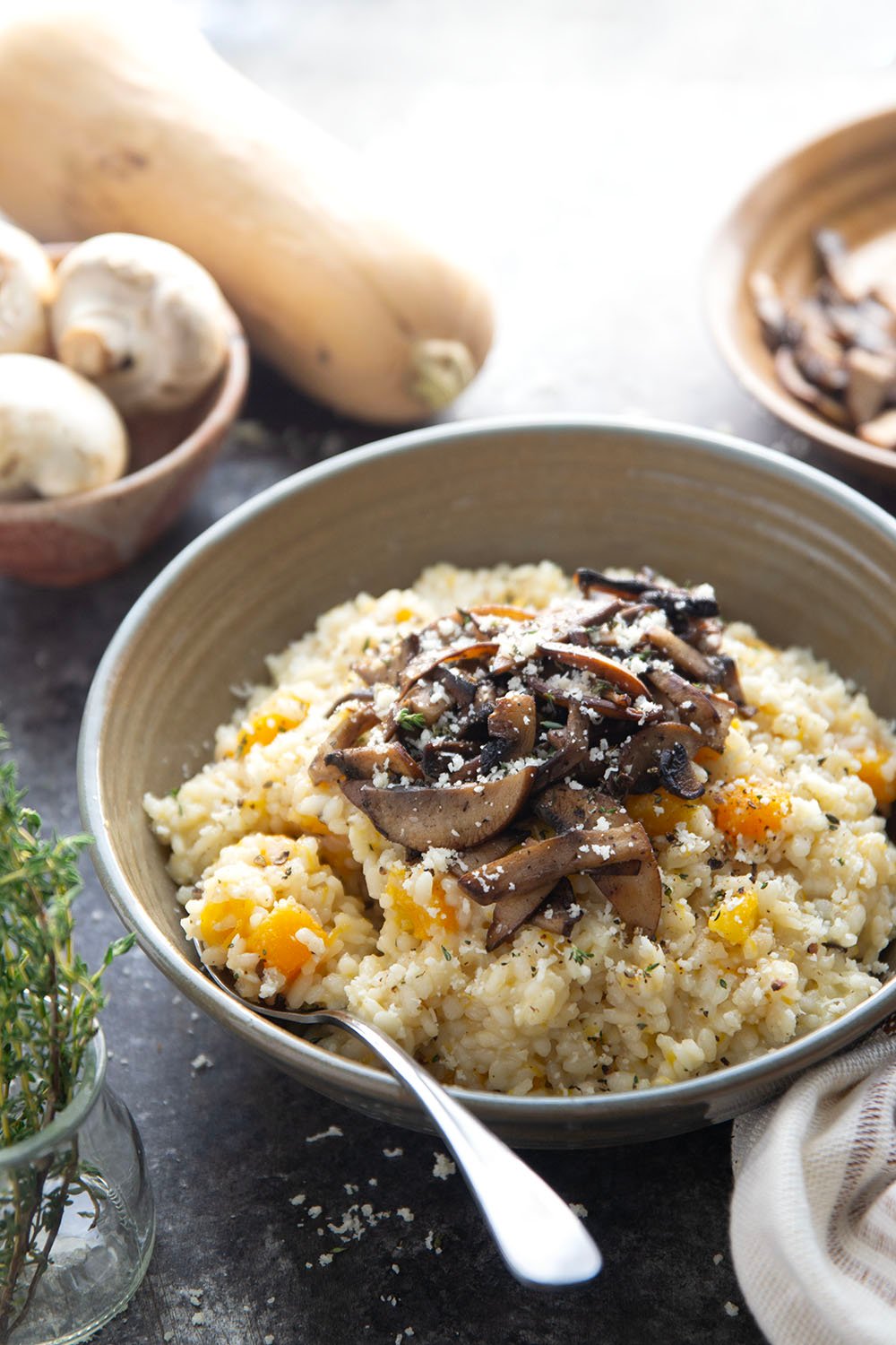 Rich and creamy butternut squash risotto is cooked with plenty of tender butternut squash cubes and nutty asiago cheese and served with crispy fried mushrooms on top.