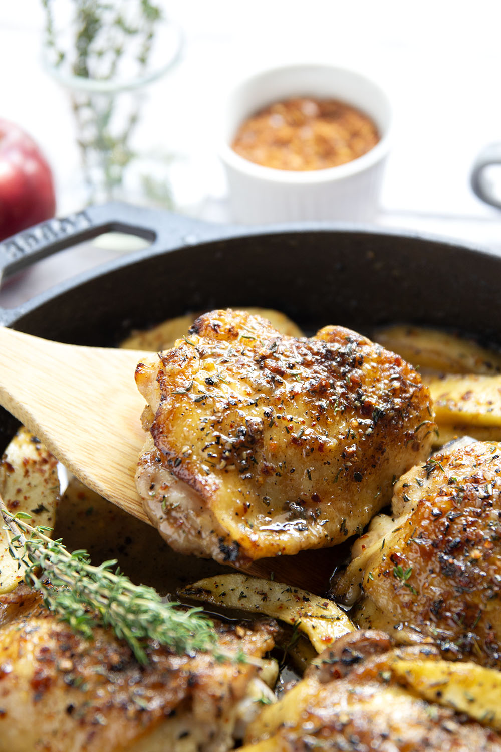 Baked alongside tender fall apples in a sweet and spicy chili maple glaze, these maple chicken thighs are a quick and flavorful fall dinner for any occasion.