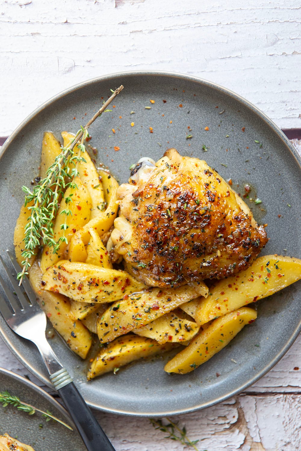 Baked alongside tender fall apples in a sweet and spicy chili maple glaze, these maple chicken thighs are a quick and flavorful fall dinner for any occasion.