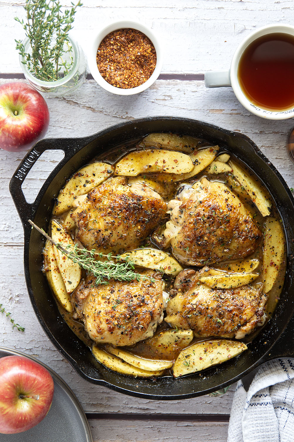 Baked alongside tender fall apples in a sweet and spicy chili maple glaze, these maple chicken thighs are a quick and flavorful fall dinner for any occasion.