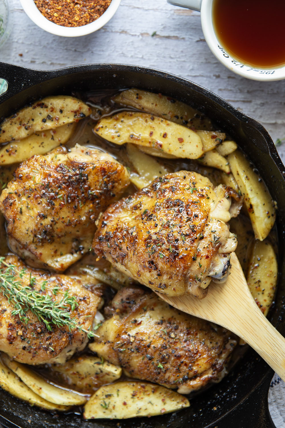 Baked alongside tender fall apples in a sweet and spicy chili maple glaze, these maple chicken thighs are a quick and flavorful fall dinner for any occasion.