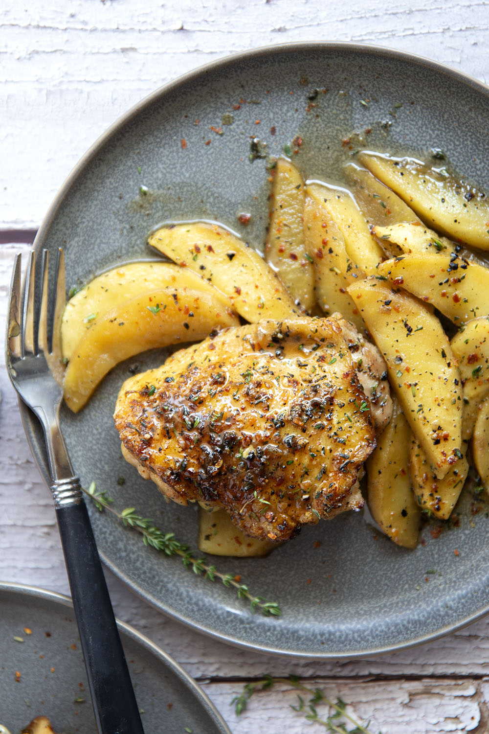 Baked alongside tender fall apples in a sweet and spicy chili maple glaze, these maple chicken thighs are a quick and flavorful fall dinner for any occasion.