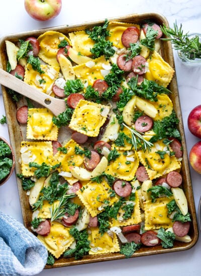 Roasted on one sheet pan and packed with fall goodness, this sheet pan ravioli is baked alongside tender sausage and apples in a sweet maple mustard sauce.