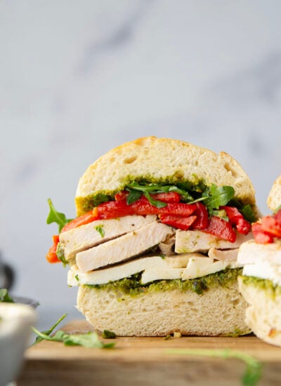 This turkey pesto sandwich features layers of fresh mozzarella, leftover turkey slices, and roasted red peppers with herby basil pesto sauce.