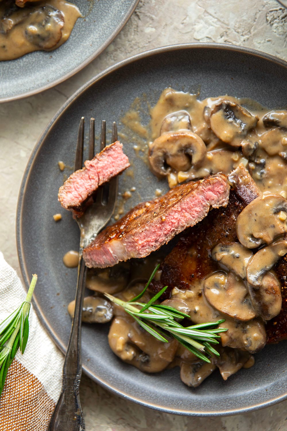 Learn how to cook a perfect restaurant-style ribeye steak with mushroom sauce with this keeper recipe. The steak sears up buttery tender every time and is fantastic with a creamy stout mushroom sauce draped over top.