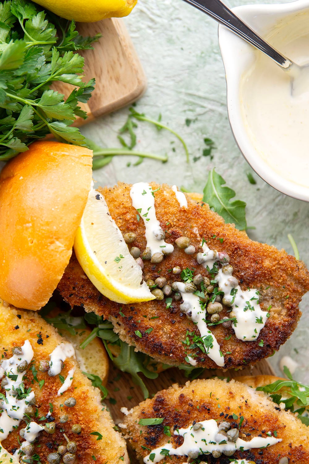 This chicken piccata sandwich feature all the things you love about classic chicken piccata in sandwich form! Fluffy brioche buns with crispy chicken cutlets squeezed with fresh lemon, tangy capers, peppery argula, and a creamy lemon aioli.