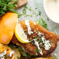 This chicken piccata sandwich feature all the things you love about classic chicken piccata in sandwich form! Fluffy brioche buns with crispy chicken cutlets squeezed with fresh lemon, tangy capers, peppery argula, and a creamy lemon aioli.