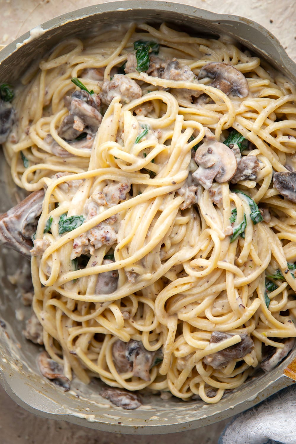 Tender sauteed mushrooms, sausage, and spinach spruce up this creamy sausage fettuccine alfredo into a luxurious pasta dinner.