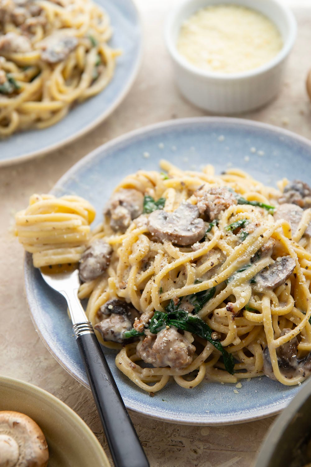 Tender sauteed mushrooms, sausage, and spinach spruce up this creamy sausage fettuccine alfredo into a luxurious pasta dinner.