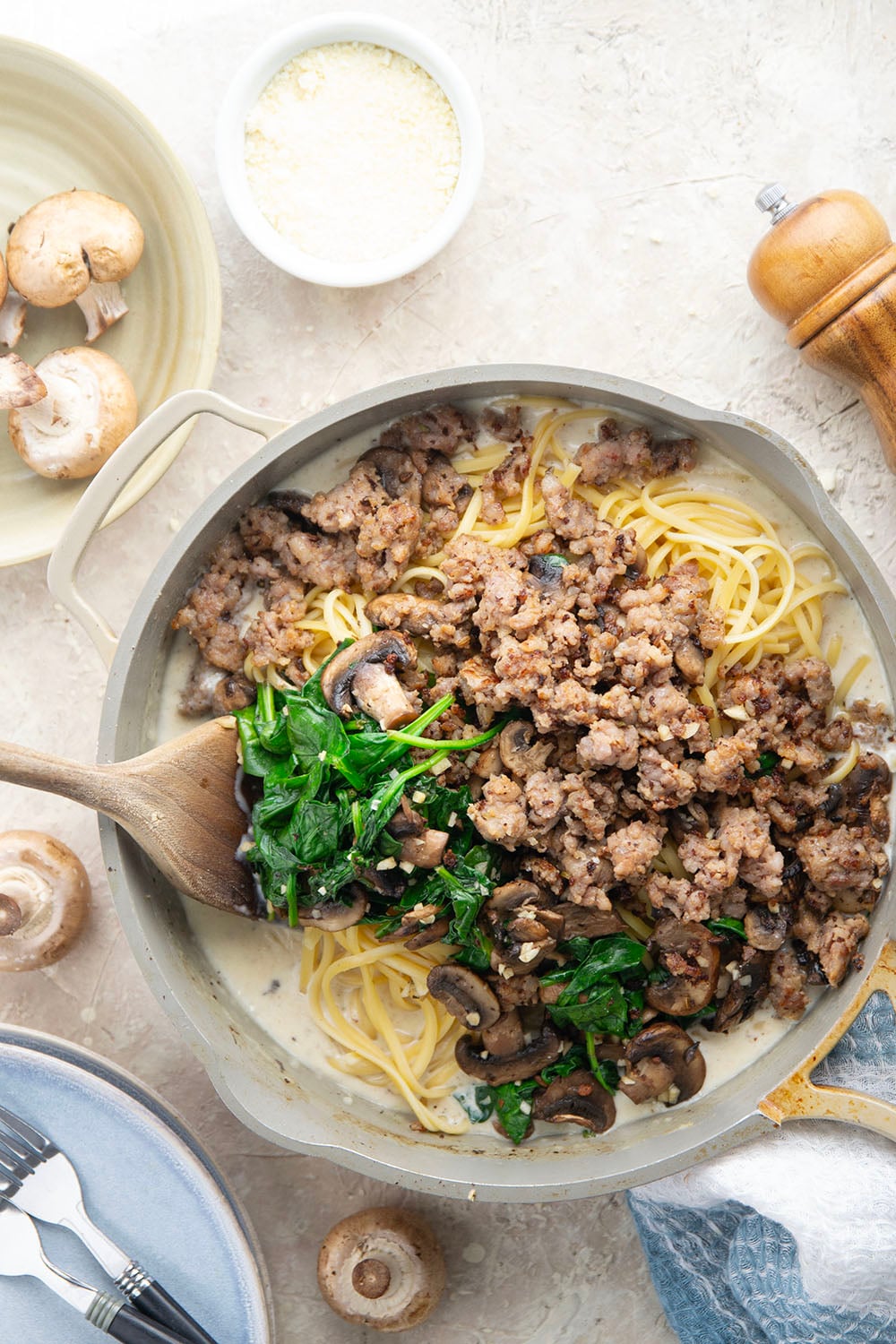 Tender sauteed mushrooms, sausage, and spinach spruce up this creamy sausage fettuccine alfredo into a luxurious pasta dinner.