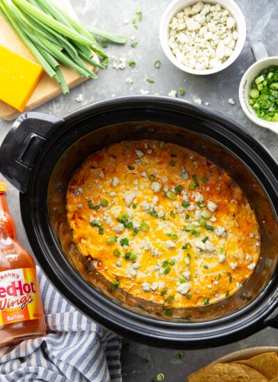 Cooked completely in the slow cooker with virtually zero effort and packed with fall-apart tender chicken in a rich and cheesy buffalo sauce, this slow cooker buffalo chicken dip is a game day snack essential!