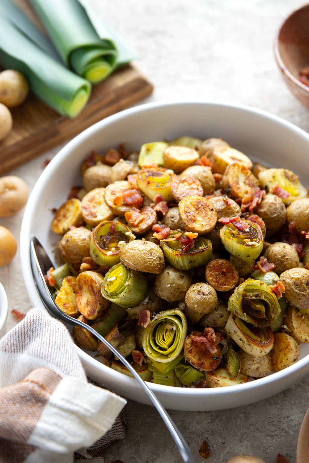Roasted in flavorful bacon drippings until perfectly crispy and tender and tossed with crisp bacon bits, these roasted potatoes and leeks are the easiest side dish that goes well with any meal.