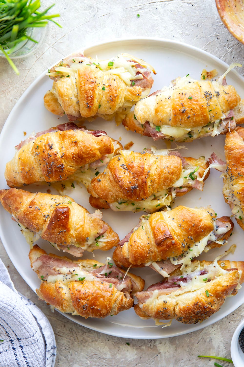 Gooey gruyere cheese, sliced deli ham, and a chive honey mustard spruce up classic ham and cheese croissant sliders into a winning appetizer that will disappear within minutes every time!