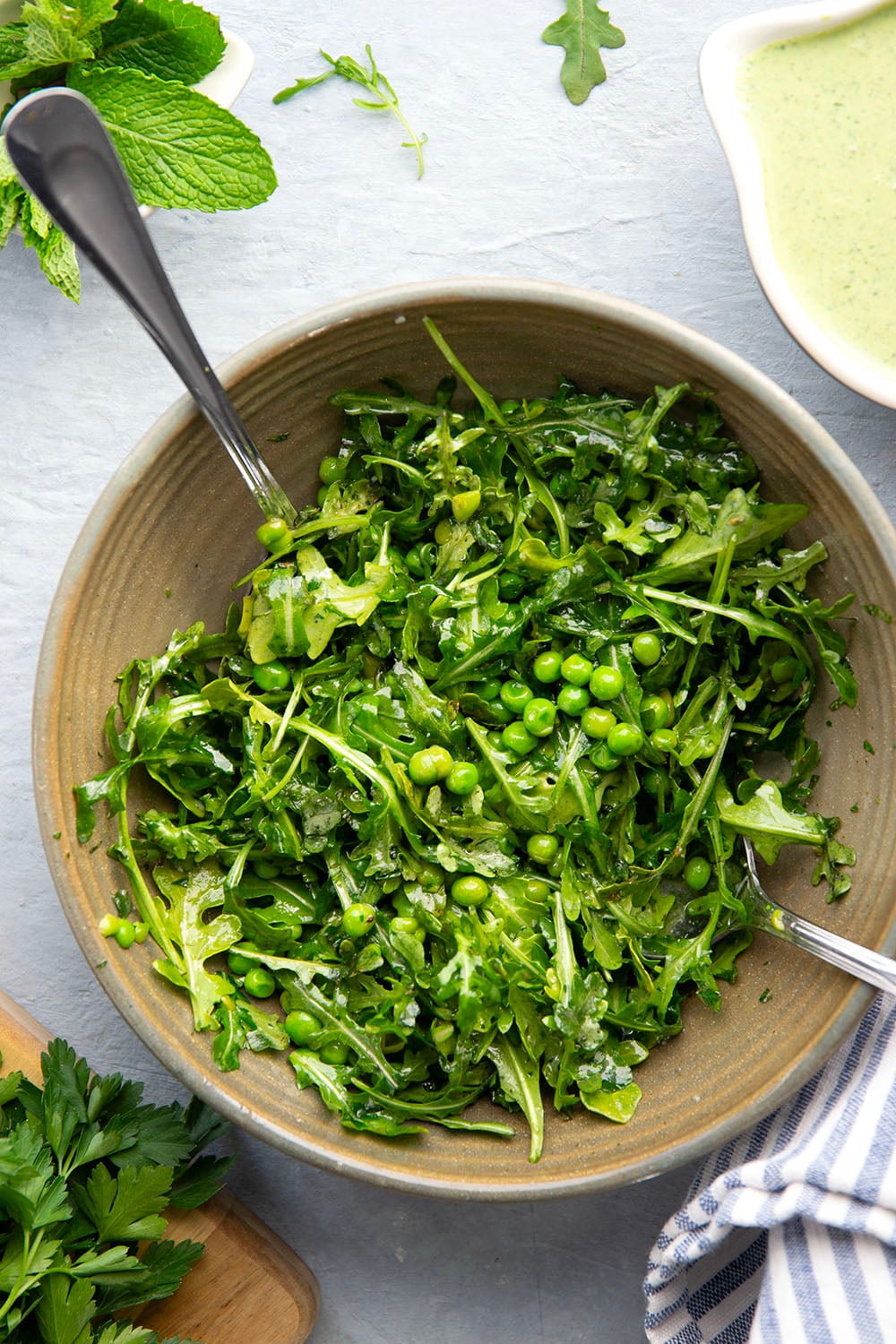 Juicy seared turkey patties are served on an herby green goddess sauce with lots of fresh arugula pea salad piled on top for a super fresh spring dinner.