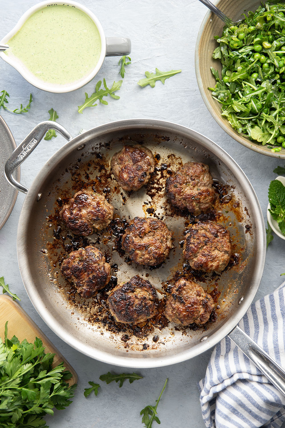 Juicy seared turkey patties are served on an herby green goddess sauce with lots of fresh arugula pea salad piled on top for a super fresh spring dinner.