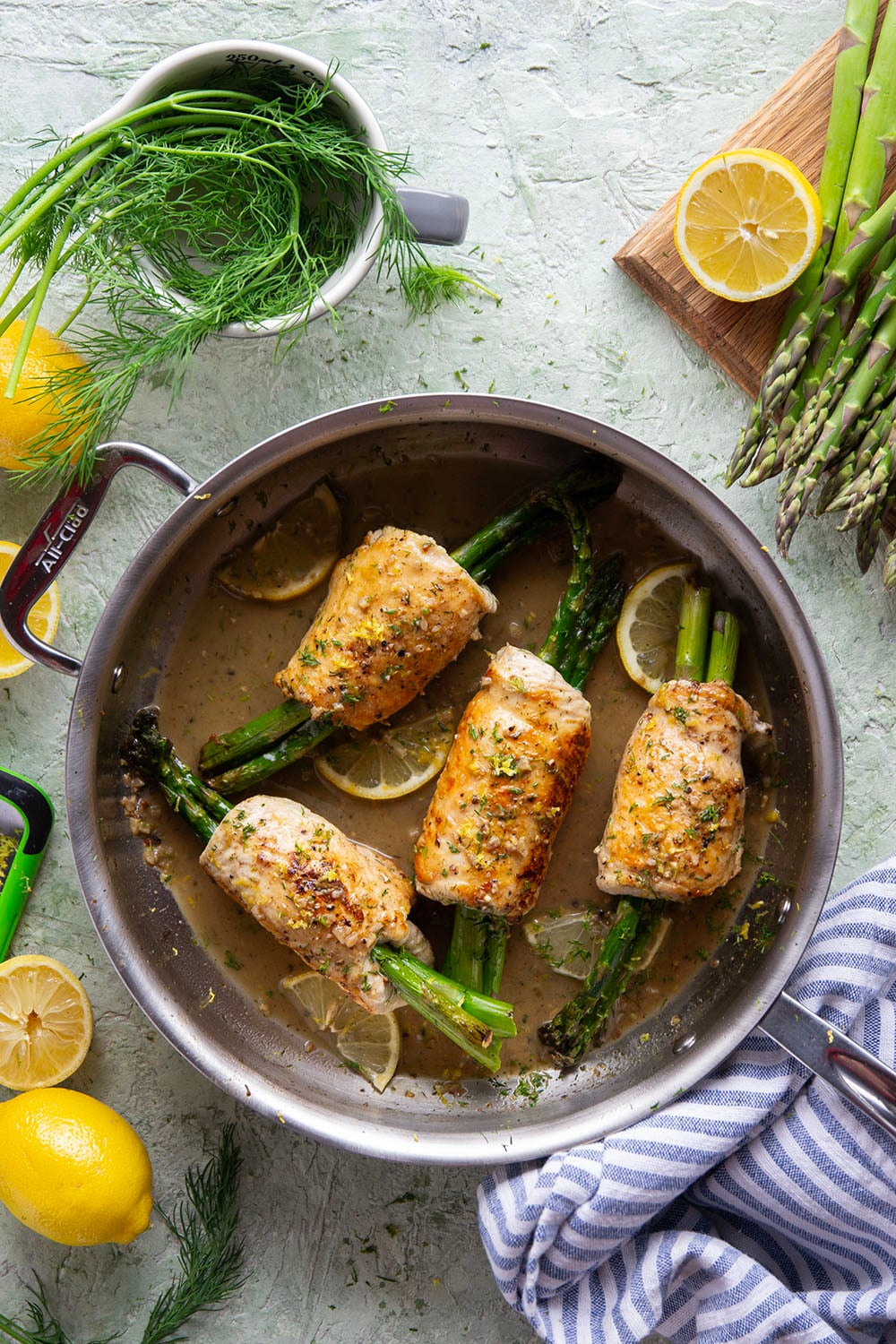 Asparagus chicken roll-ups feature chicken breast cutlets with tender asparagus spears rolled up inside and a garlicky lemon dill sauce spooned on top.