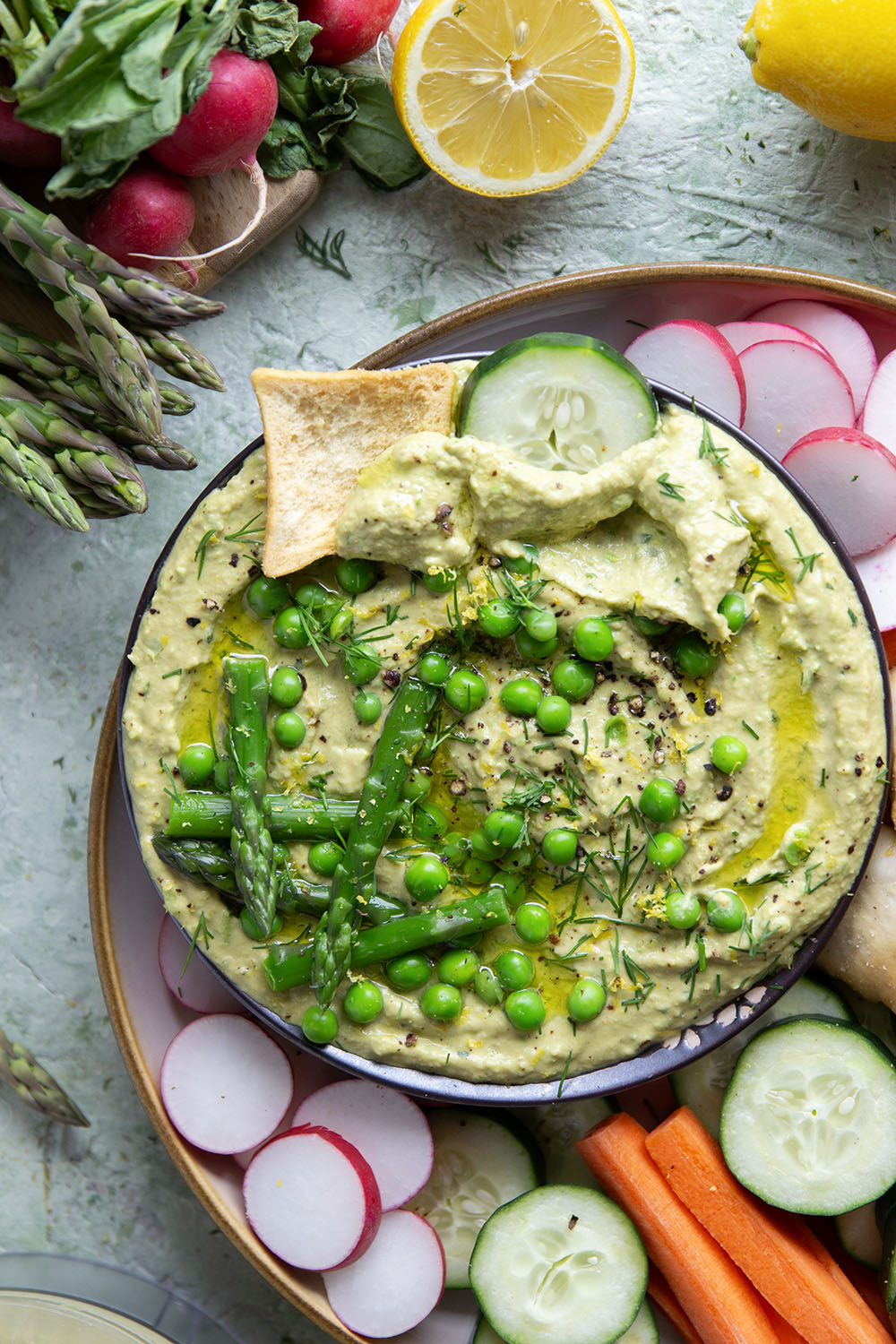 Vibrant spring peas and asparagus are the best spring twist on hummus! This asparagus pea hummus is silky smooth and pairs wonderfully with fresh vegetables and pita chips for dipping.