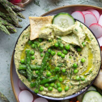 Vibrant spring peas and asparagus are the best spring twist on hummus! This asparagus pea hummus is silky smooth and pairs wonderfully with fresh vegetables and pita chips for dipping.