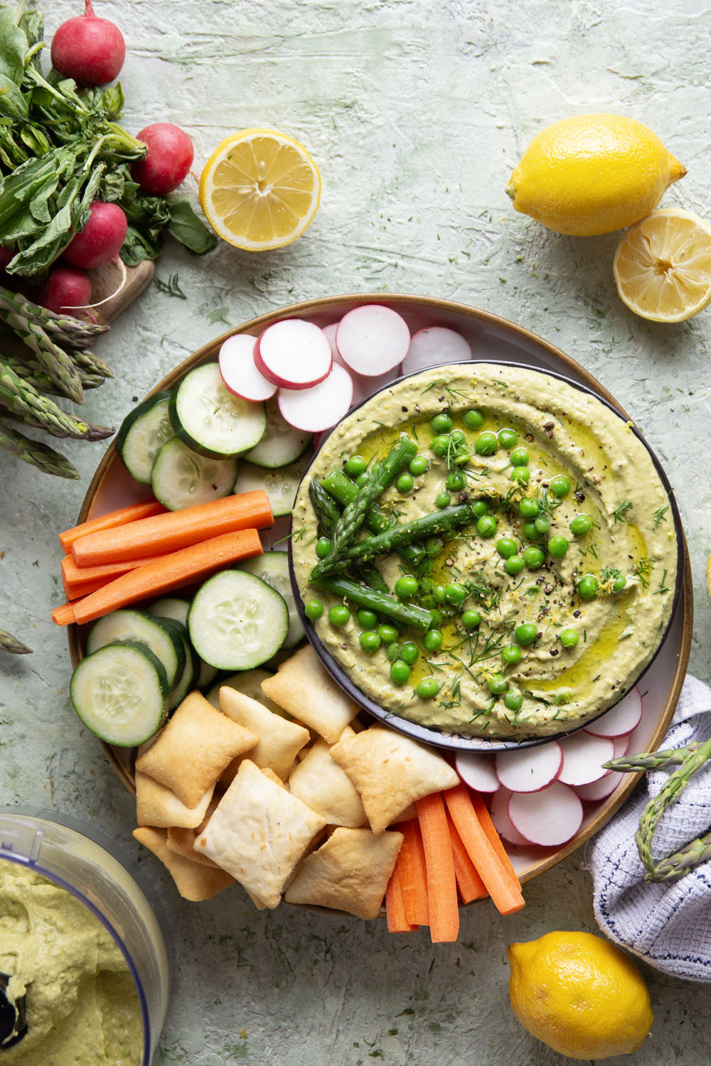 Vibrant spring peas and asparagus are the best spring twist on hummus! This asparagus pea hummus is silky smooth and pairs wonderfully with fresh vegetables and pita chips for dipping.