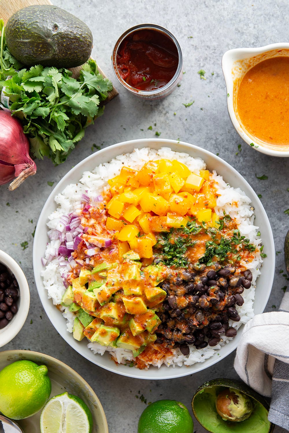 This black bean rice salad features fluffy steamed rice with black beans, sweet peppers, and avocado dressed in a sweet and spicy honey chipotle dressing.