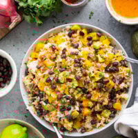 This black bean rice salad features fluffy steamed rice with black beans, sweet peppers, and avocado dressed in a sweet and spicy honey chipotle dressing.