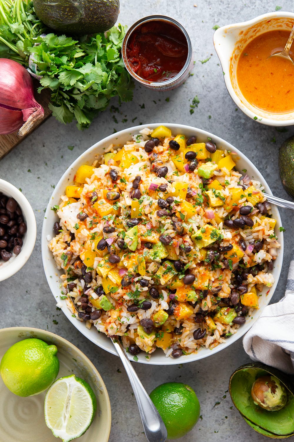 This black bean rice salad features fluffy steamed rice with black beans, sweet peppers, and avocado dressed in a sweet and spicy honey chipotle dressing.