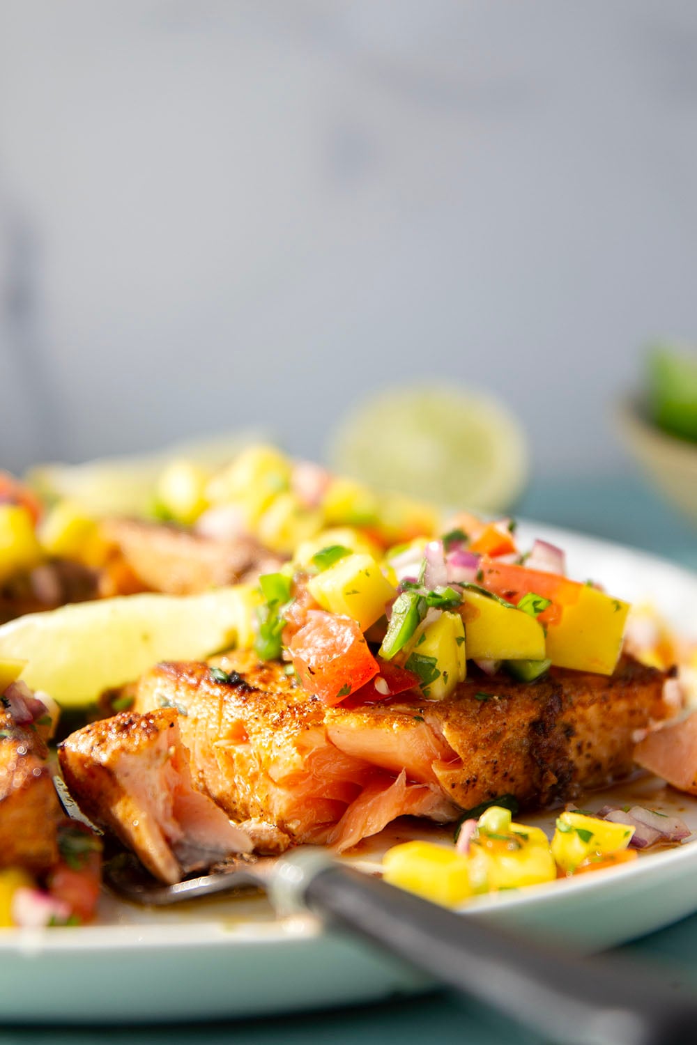 Marinated in a fresh lime and chili sauce, grilled to perfection, and topped with a super fresh mango salsa, this grilled chili lime salmon is an easy dinner that's full of flavor!