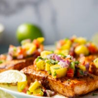 Marinated in a fresh lime and chili sauce, grilled to perfection, and topped with a super fresh mango salsa, this grilled chili lime salmon is an easy dinner that's full of flavor!