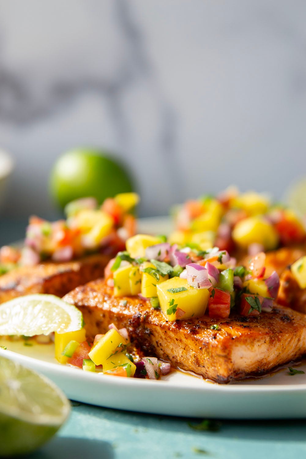 Marinated in a fresh lime and chili sauce, grilled to perfection, and topped with a super fresh mango salsa, this grilled chili lime salmon is an easy dinner that's full of flavor!