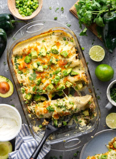 Flavorful poblanos and ground turkey make up a hearty filling in these ground turkey enchiladas that bake up with a cheesy white enchilada sauce on top and lots of toppings.