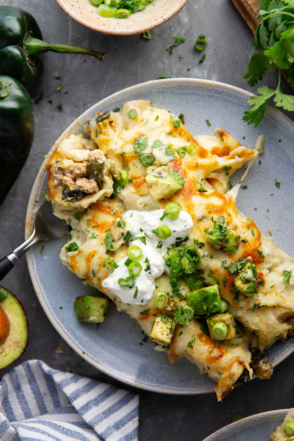 Flavorful poblanos and ground turkey make up a hearty filling in these ground turkey enchiladas that bake up with a cheesy white enchilada sauce on top and lots of toppings.