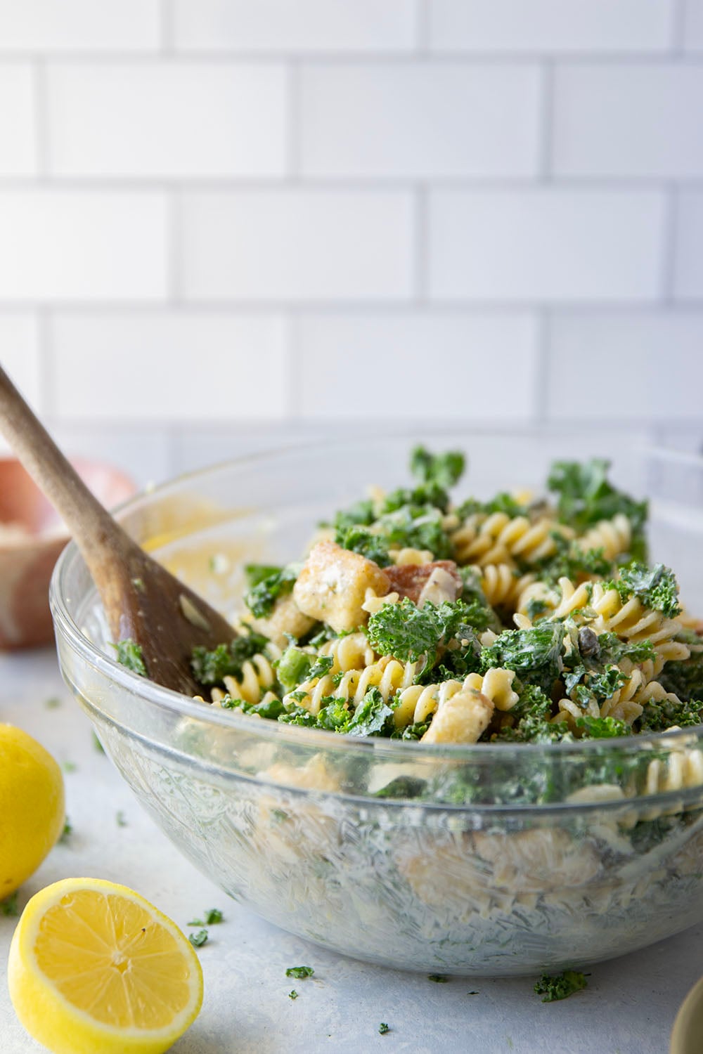 Packed with tender chopped kale, pasta, and all the caesar salad works including a homemade lemon caesar dressing, this kale caesar pasta salad will soon be a cookout staple for the summer.