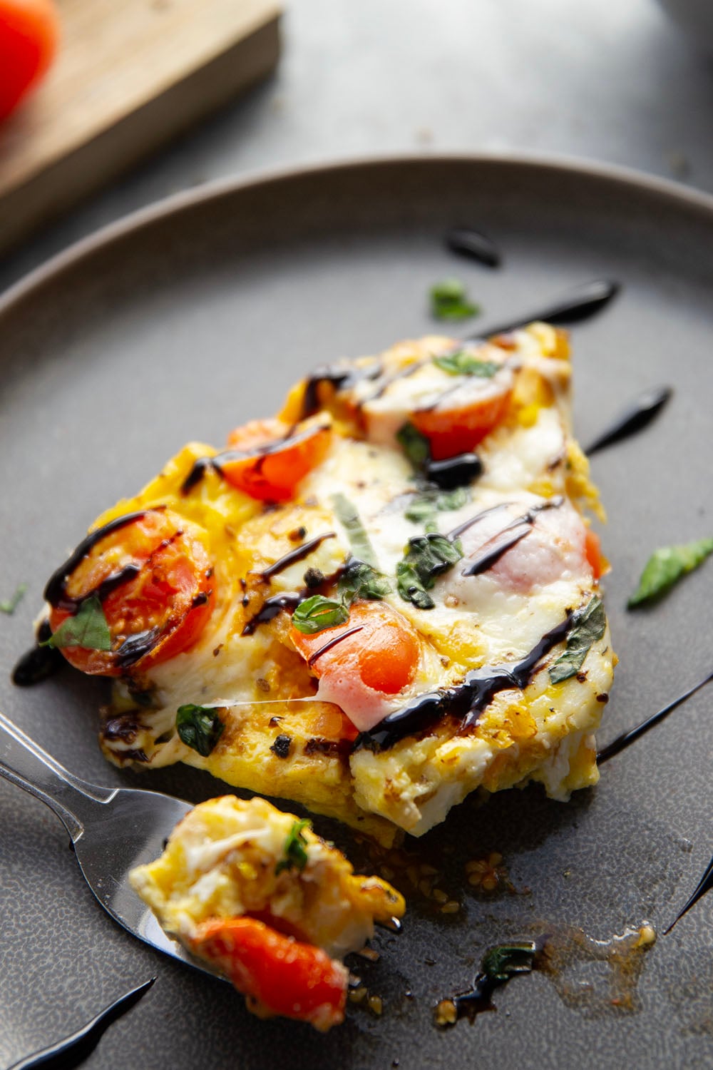 This caprese frittata couldn't be easier to whip up and feature a base of fluffy eggs, sweet cherry tomatoes, gooey fresh mozzarella, and lots of fresh basil and balsamic glaze on top.