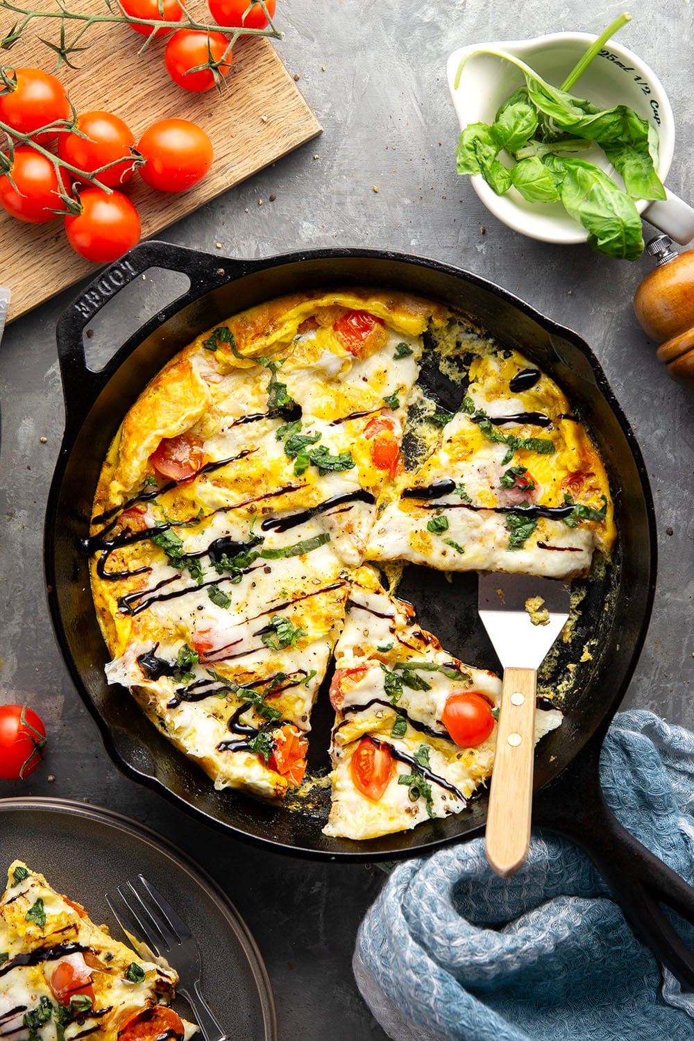 This caprese frittata couldn't be easier to whip up and feature a base of fluffy eggs, sweet cherry tomatoes, gooey fresh mozzarella, and lots of fresh basil and balsamic glaze on top.