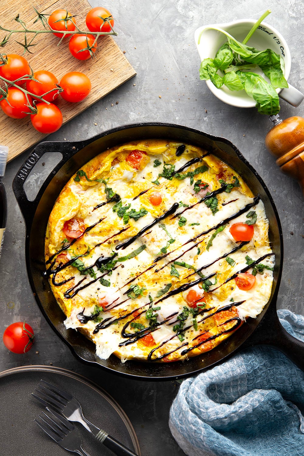 This caprese frittata couldn't be easier to whip up and feature a base of fluffy eggs, sweet cherry tomatoes, gooey fresh mozzarella, and lots of fresh basil and balsamic glaze on top.