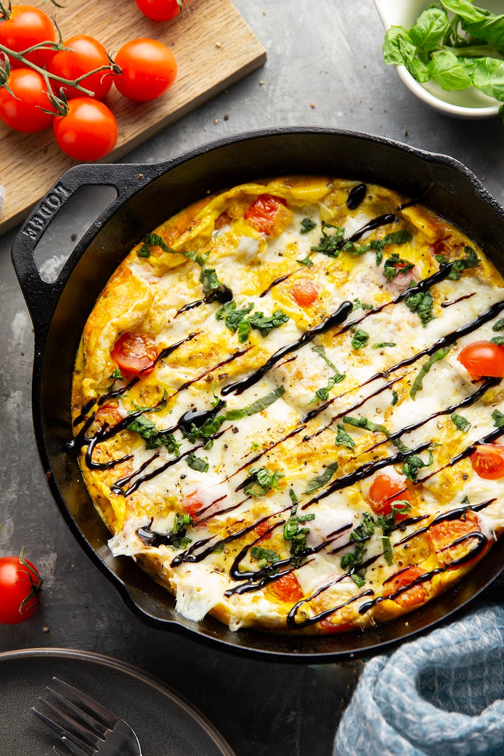 This caprese frittata couldn't be easier to whip up and feature a base of fluffy eggs, sweet cherry tomatoes, gooey fresh mozzarella, and lots of fresh basil and balsamic glaze on top.