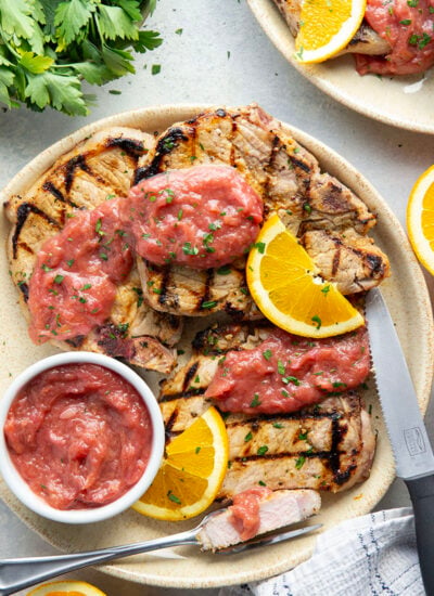 These grilled orange pork chops feature pork chops marinated in a fresh orange marinade, grilled until perfectly juicy, and served with a sweet and tangy rhubarb compote.