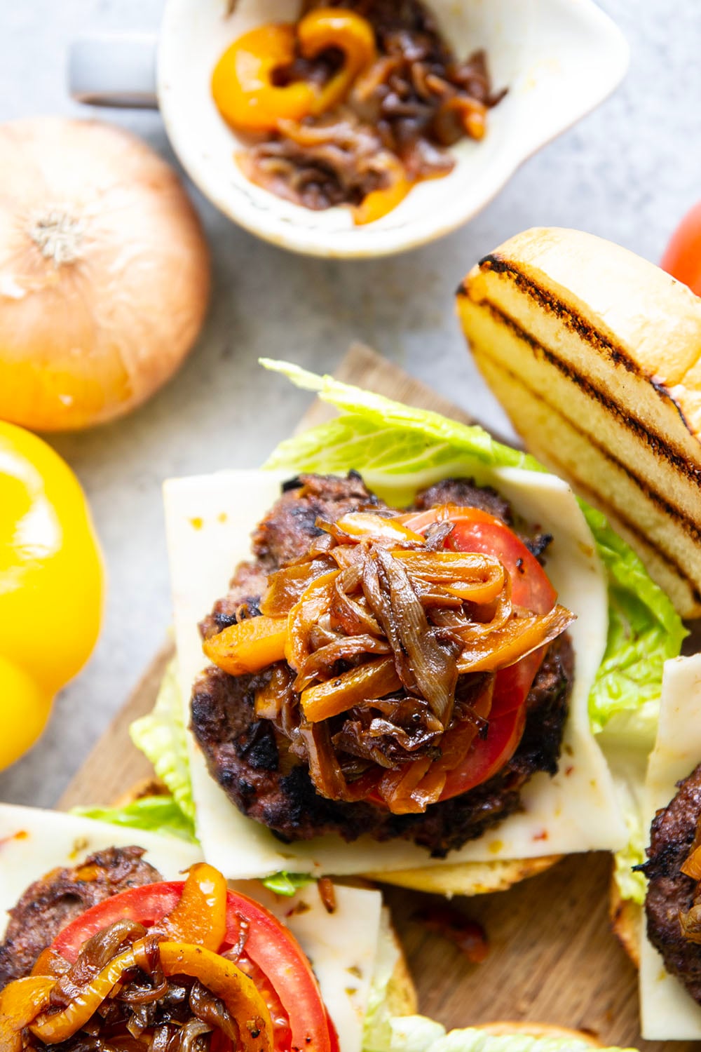 This juicy caramelized onion burger features caramelized onions and sweet peppers packed both inside the burger for extra flavor and more piled on top with a slice of pepperjack cheese and crisp lettuce.
