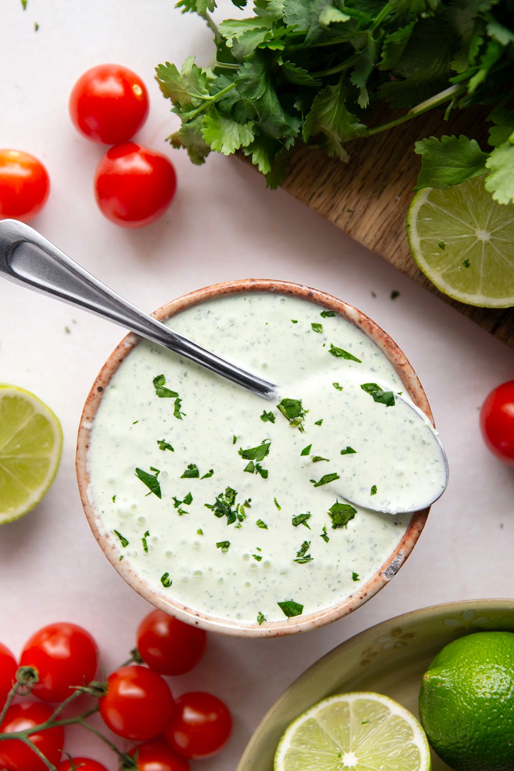 Marinated in a fresh cilantro lime sauce and grilled alongside red onion, cherry tomatoes, and served with a cilantro lime crema, these cilantro lime grilled salmon kabobs are a quick dinner to throw on the grill for any occasion.